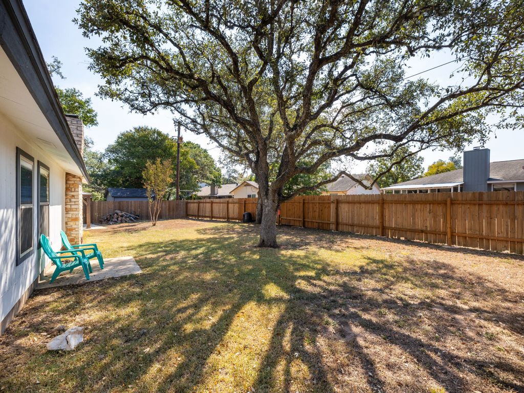 5001 Summerset Trail Austin, TX 78749 - Photo 7 of 11 a backyard of a house with table and chairs and wooden fence