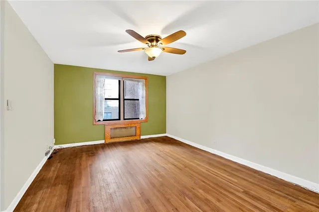 an empty room with windows and ceiling fan