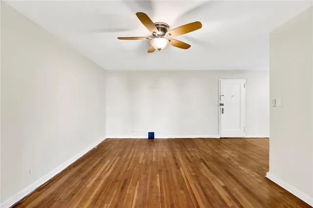a view of a room with wooden floor and ceiling fan