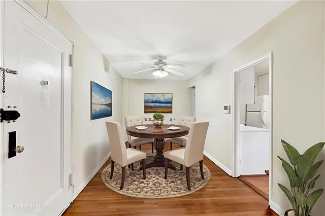 a dining room with wooden floor a chandelier a wooden table and chairs