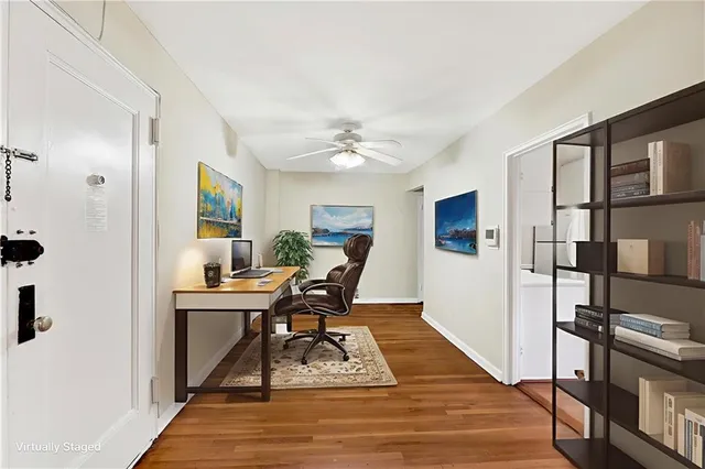 a view of a workspace with furniture and a window