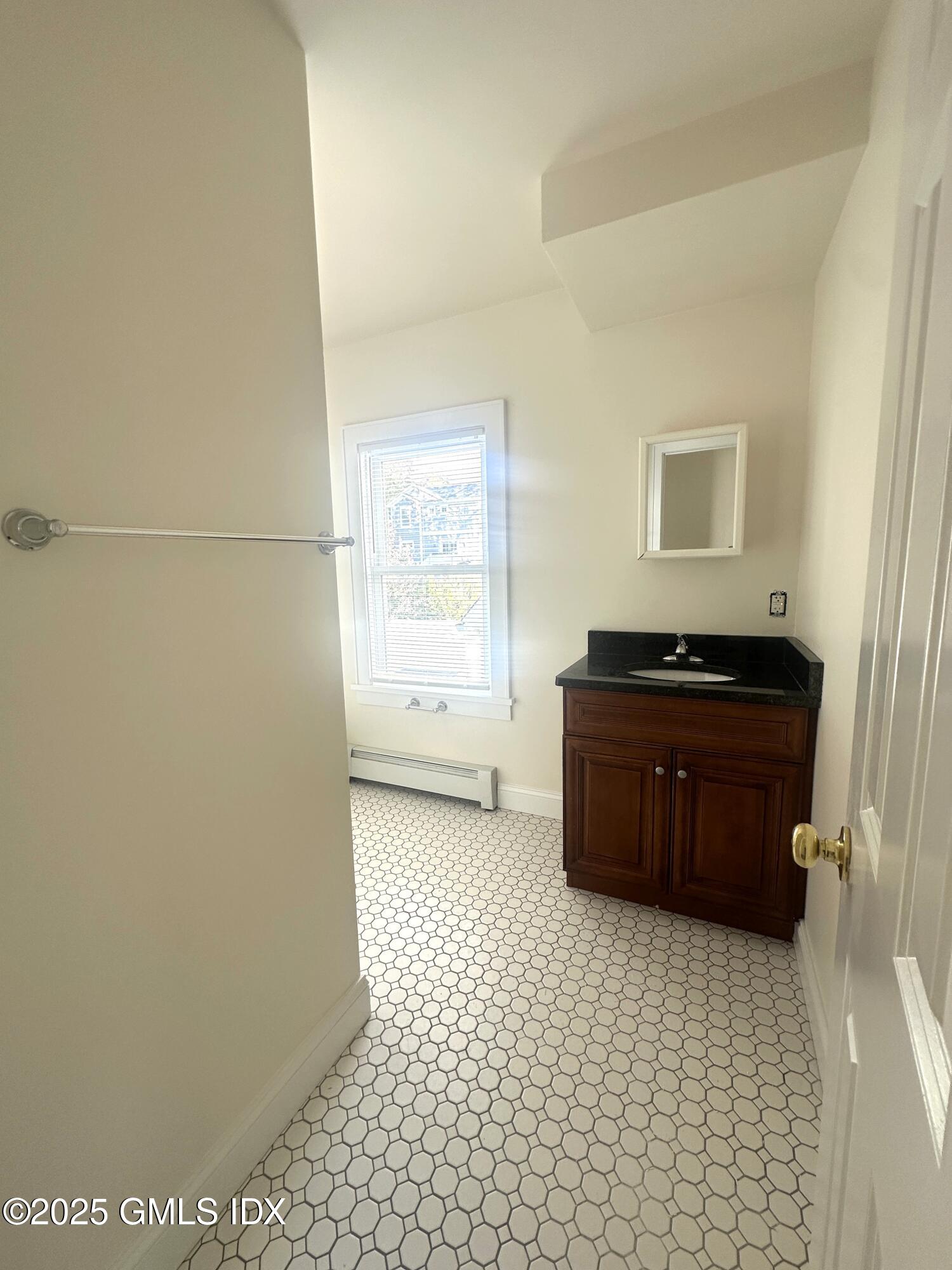 85 Strickland Road, Unit 2 Cos Cob, CT 06807 - Photo 13 of 26 a bathroom with a granite countertop sink a vanity and a window