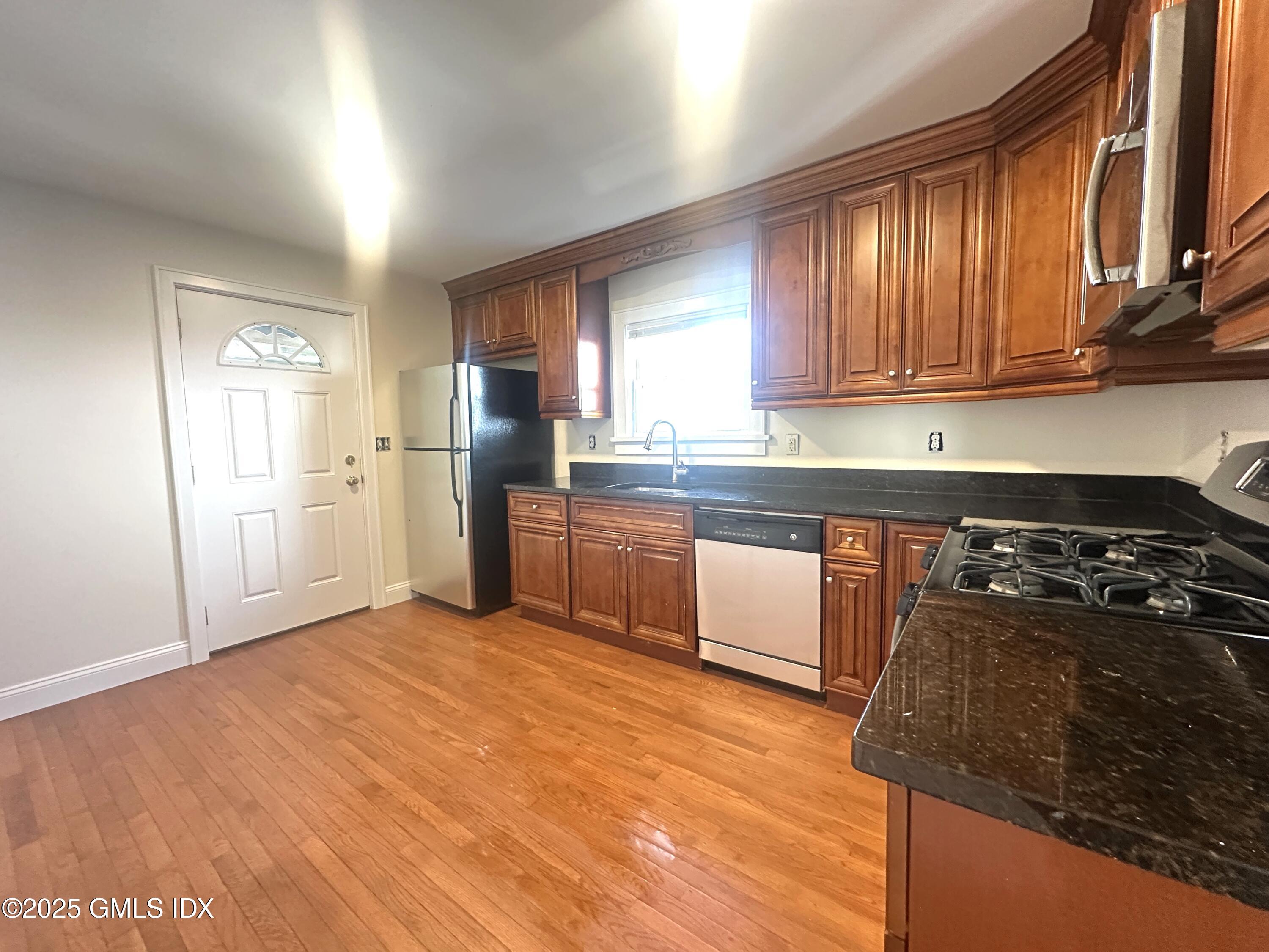 85 Strickland Road, Unit 2 Cos Cob, CT 06807 - Photo 4 of 26 a kitchen with stainless steel appliances granite countertop a stove a sink dishwasher and a refrigerator