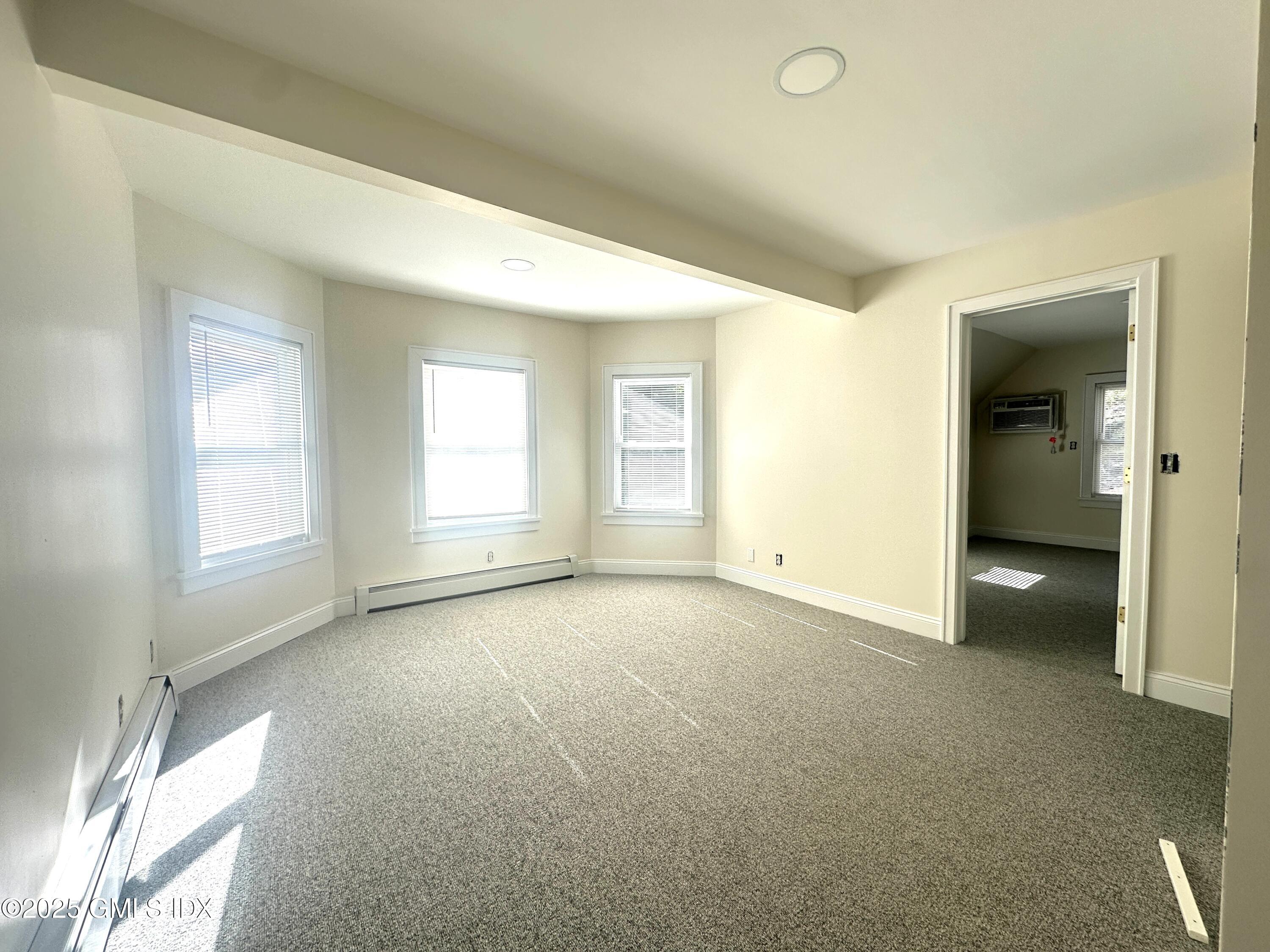 85 Strickland Road, Unit 2 Cos Cob, CT 06807 - Photo 7 of 26 an empty room with windows and entrance