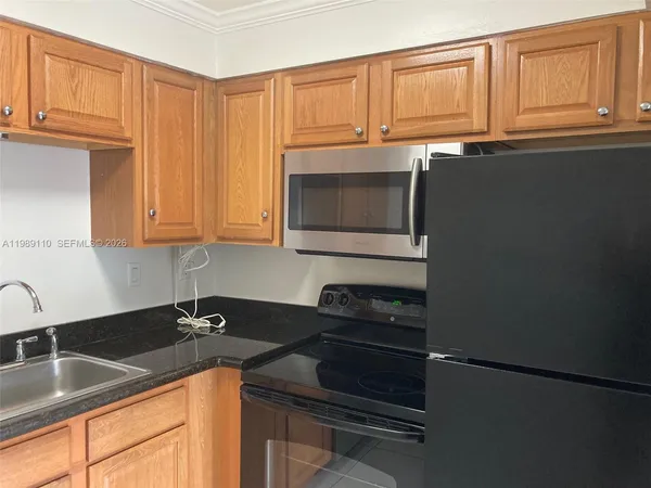 a kitchen with granite countertop a sink stove and cabinets