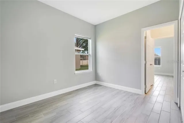 an empty room with wooden floor and a window