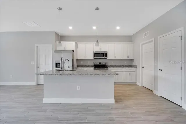 a kitchen with stainless steel appliances granite countertop a stove a sink and a refrigerator