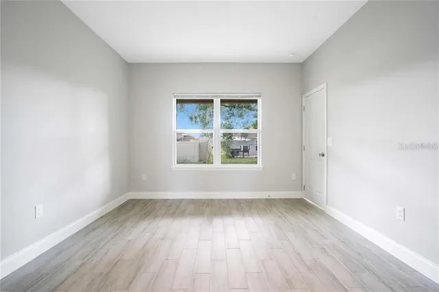 wooden floor in an empty room with a window