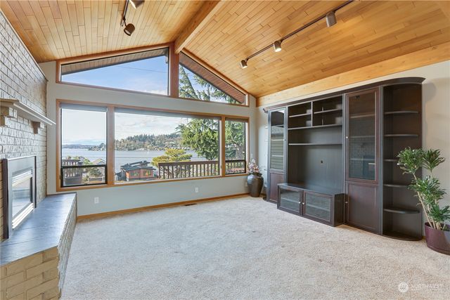 a view of an empty room with a window and kitchen view
