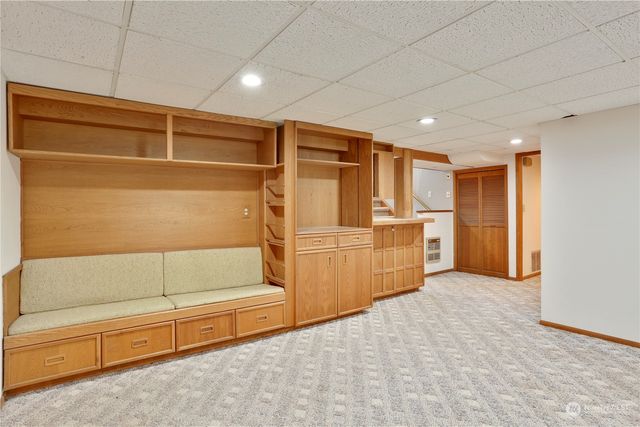 a livingroom with kitchen cabinets and stainless steel appliances