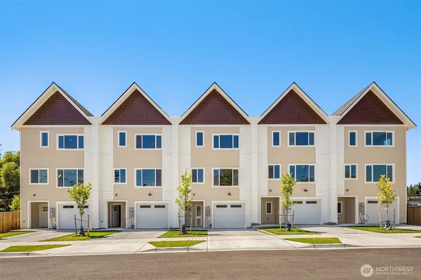 a view of a white house with a large windows and plants