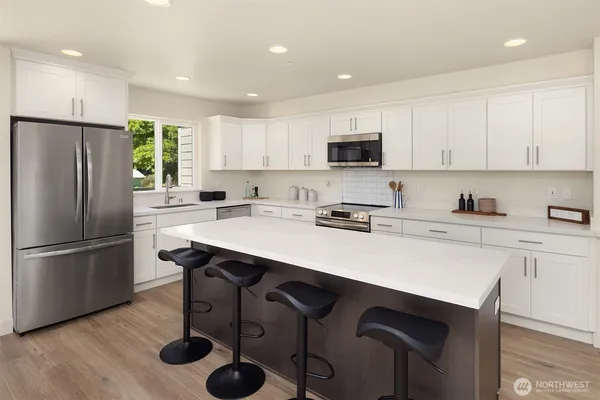 a kitchen with a sink a refrigerator a stove a microwave and cabinets