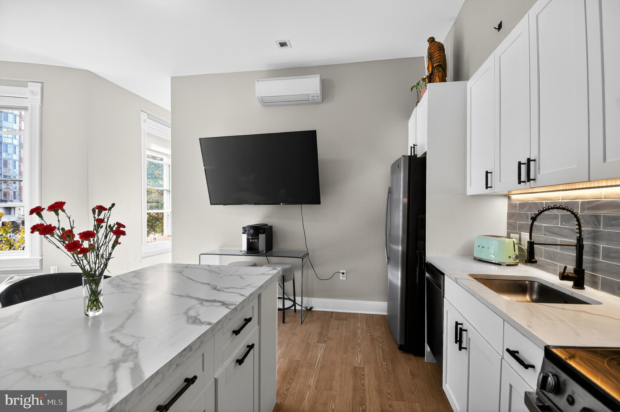 459 Massachusetts Avenue Northwest, Unit 24 Washington, DC 20001 - Photo 9 of 18 a kitchen with stainless steel appliances white cabinets a sink and a hard wood floor