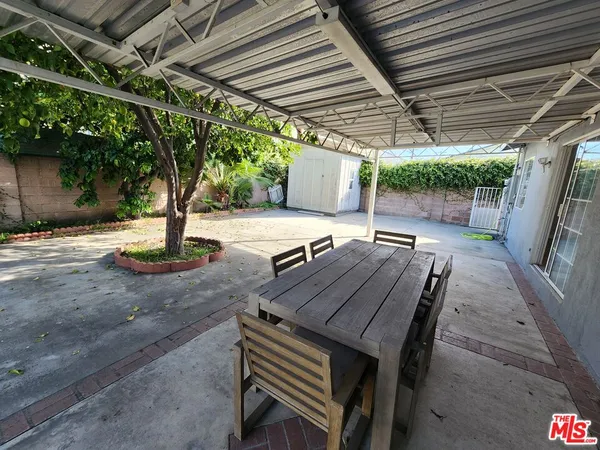 a view of a patio with table and chairs with wooden floor and fence
