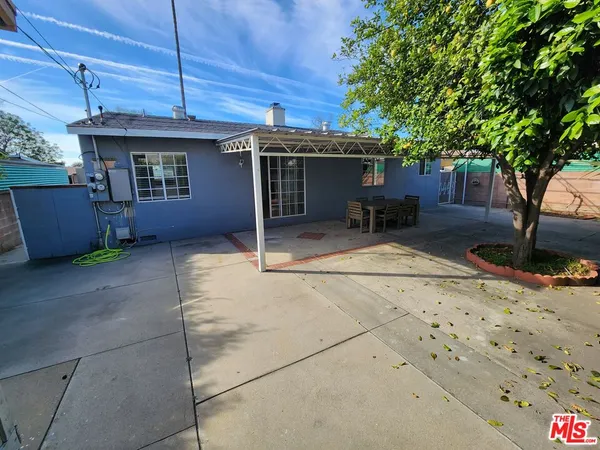 a view of a house with a patio and a yard
