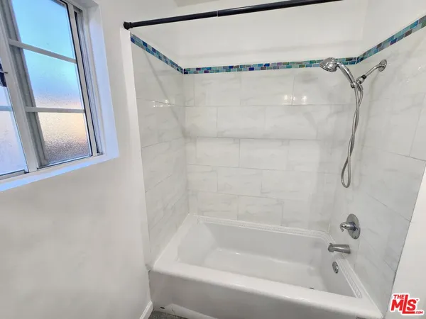 a bathroom with a shower and a bath tub