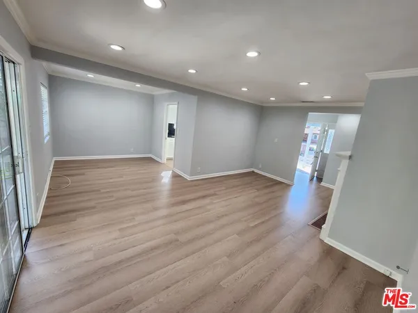 an empty room with wooden floor and staircase