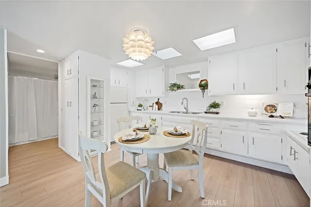 a kitchen with stainless steel appliances a dining table chairs and white cabinets