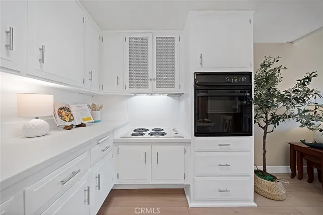a kitchen with white cabinets and appliances