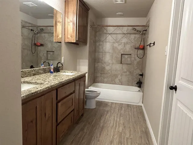 a bathroom with a granite countertop sink toilet and shower