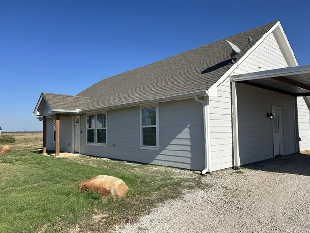 a backyard of a house with table and chairs