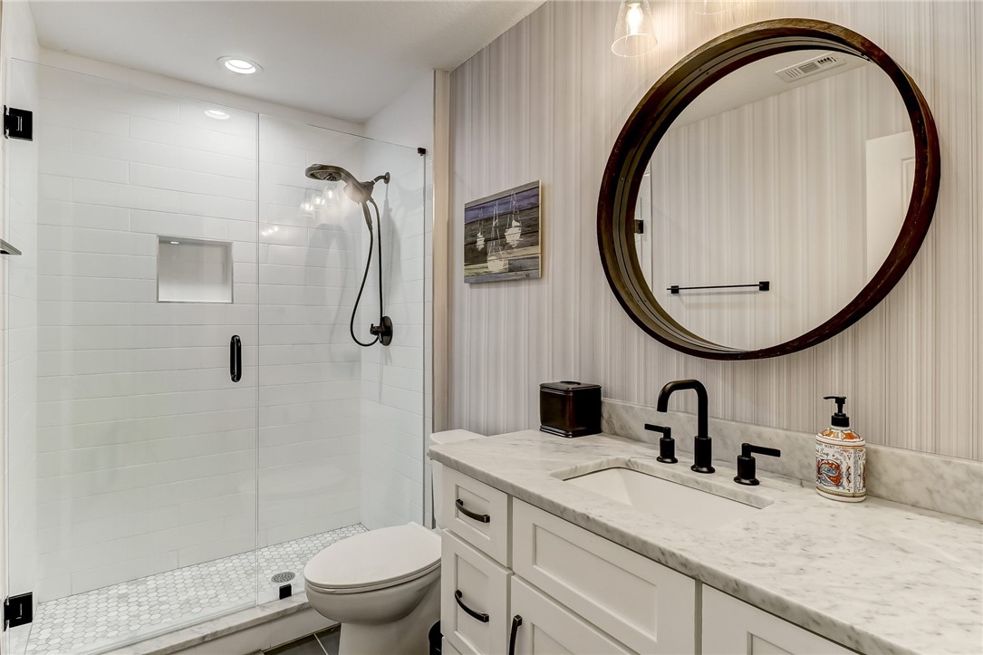 75 Sea Marsh Road Fernandina Beach, FL 32034 - Photo 20 of 30 a bathroom with a granite countertop toilet a sink and a mirror