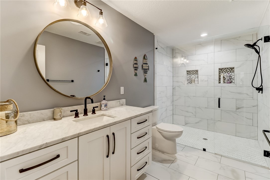 75 Sea Marsh Road Fernandina Beach, FL 32034 - Photo 24 of 30 a bathroom with a double vanity sink toilet mirror and shower