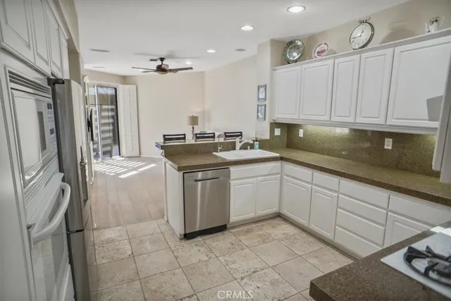 a kitchen with granite countertop white cabinets and white appliances
