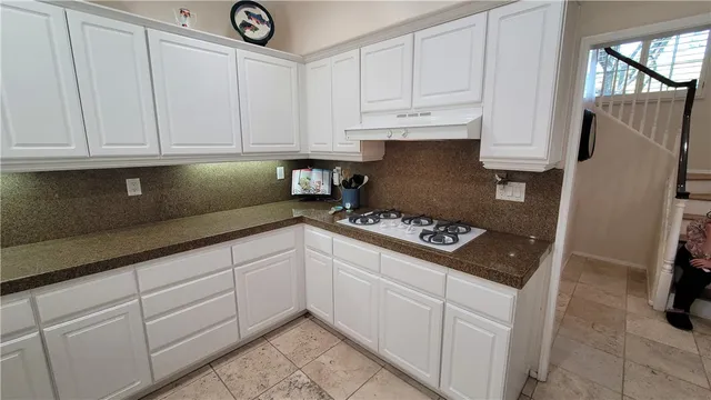 a bathroom with a granite countertop sink a toilet a mirror and shower
