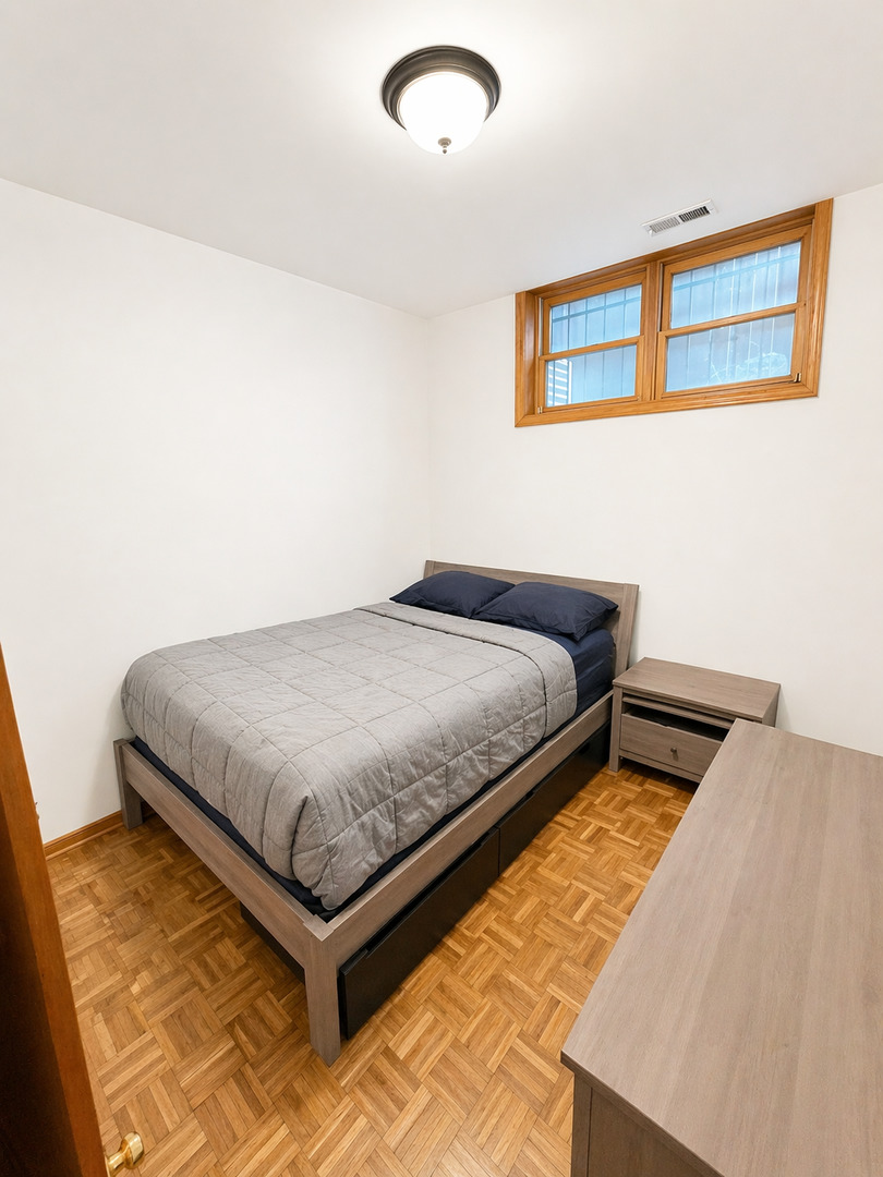 4237 North Kenmore Avenue, Unit GN Chicago, IL 60613 - Photo 11 of 12 a bedroom with a bed and a painting on the wall