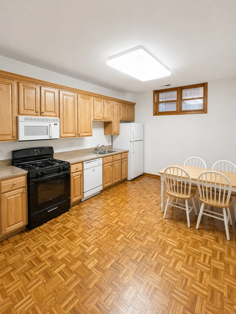 4237 North Kenmore Avenue, Unit GN Chicago, IL 60613 - Photo 12 of 12 a kitchen with a stove a sink and a dining table