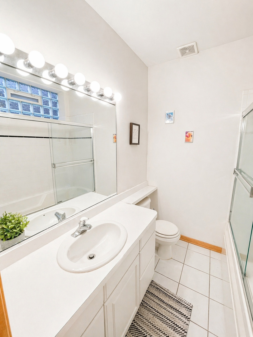 4237 North Kenmore Avenue, Unit GN Chicago, IL 60613 - Photo 10 of 12 a bathroom with a sink a toilet and a mirror