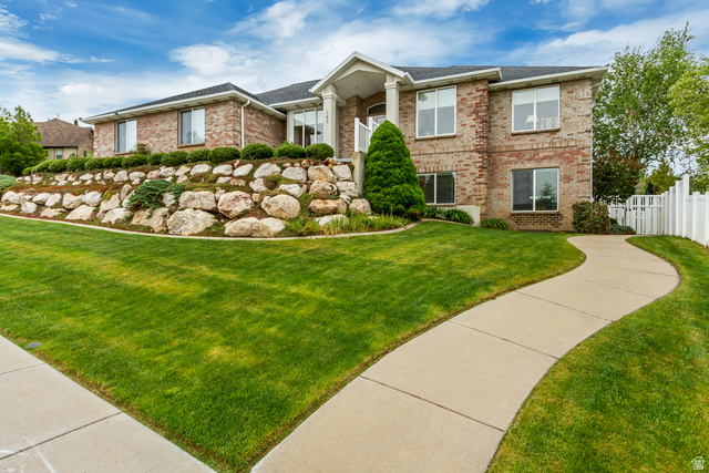 Brick exterior with white trim, featuring a prominent columned entry