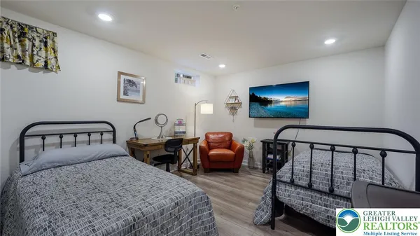 a bedroom with two beds and a flat screen tv
