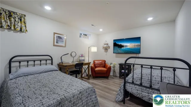 a bedroom with two beds and a flat screen tv
