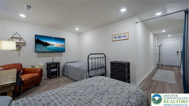 a bedroom with furniture and a flat screen tv