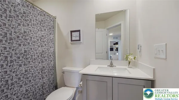 a bathroom with a granite countertop toilet sink and mirror