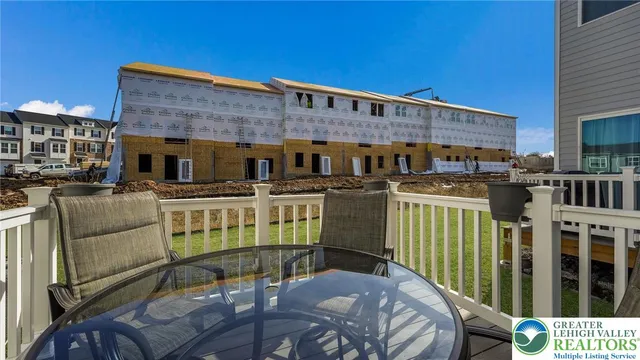 a view of a patio with couches table and chairs with wooden fence