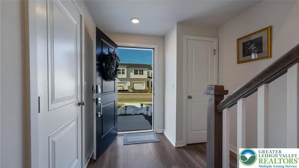 a view of a hallway with wooden floor and closet area