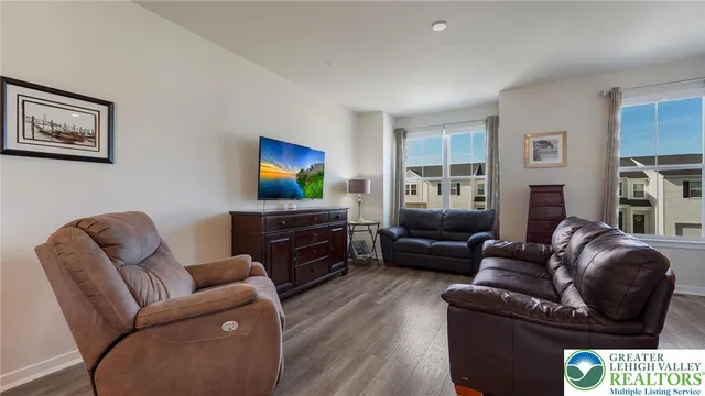 a living room with furniture a flat screen tv and a fireplace
