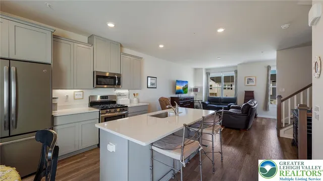 a kitchen with a sink a stove a refrigerator cabinets and wooden floor