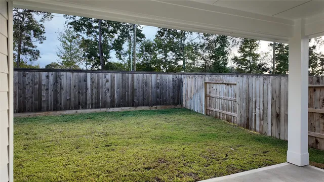 a view of a yard with wooden fence