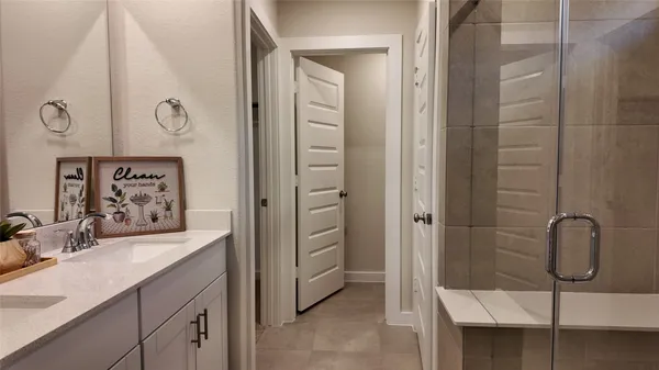 a bathroom with a granite countertop sink a mirror and shower