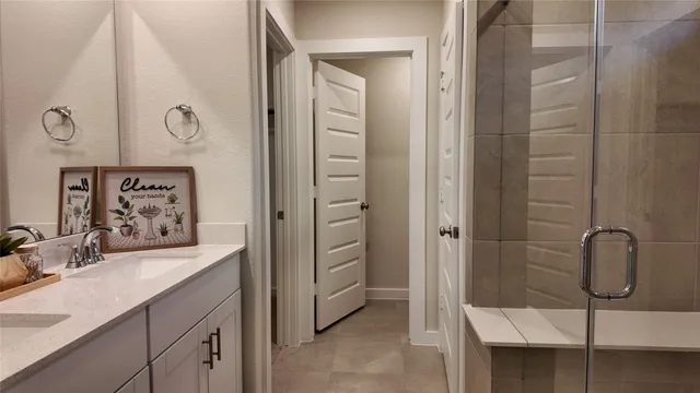 a bathroom with a granite countertop sink a mirror and shower