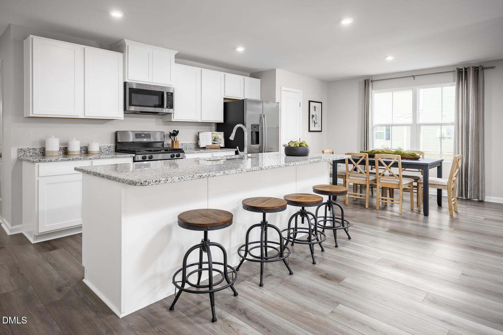 112 Cavalier Rider Run Wendell, NC 27591 - Photo 2 of 21 a kitchen with stainless steel appliances granite countertop a stove a refrigerator a microwave a dining table and chairs cabinets with wooden floor