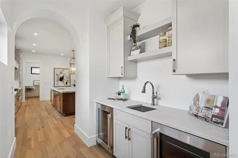 a kitchen with stainless steel appliances kitchen island granite countertop a table chairs sink and cabinets