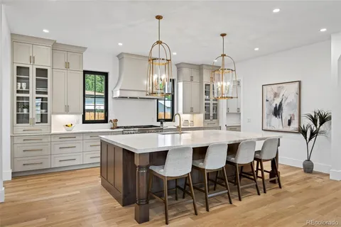 a kitchen with stainless steel appliances a dining table chairs and wooden floor