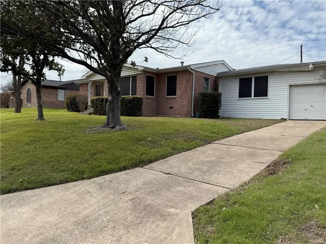 a front view of a house with a yard and trees