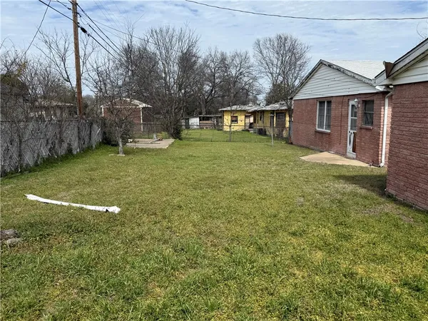 a view of a house with backyard and a tree