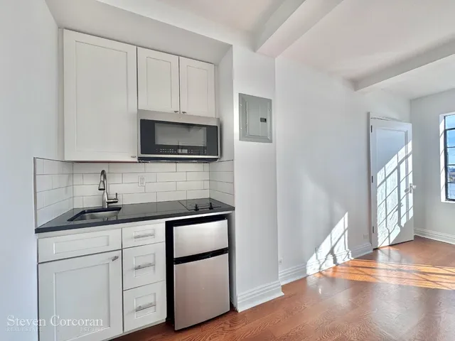 a bathroom with a sink a vanity and a microwave